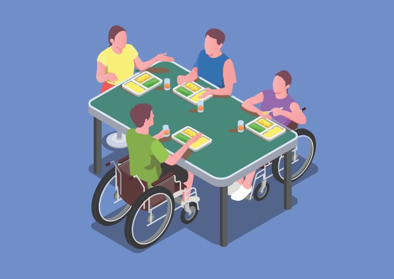 Personnes en fauteuil roulant manges à une table avec des personnes valides